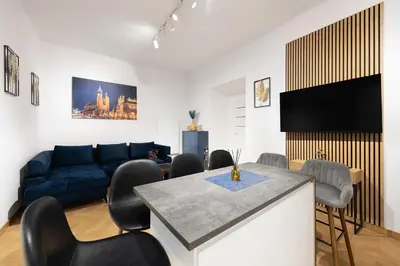 a living room with a couch and a table and chairs at Apartament Sarego Krakow Center in Kraków