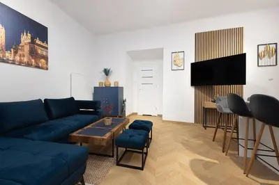 a living room with a blue couch and a table at Apartament Sarego Krakow Center in Kraków