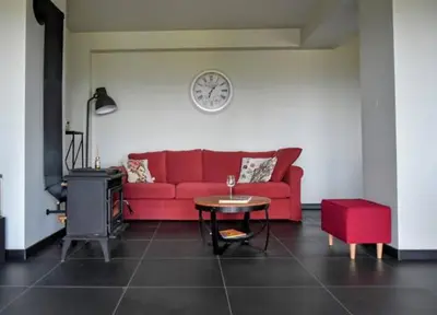 a living room with a red couch and a table at Siedlisko na Agatowej w Rudnie in Rudno