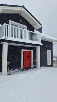 a house with a red door in the snow at Siedlisko na Agatowej w Rudnie in Rudno