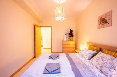 a bedroom with a large bed with white sheets at Nice and specious two bedrooms apartment in the Kraków Old Town in Kraków