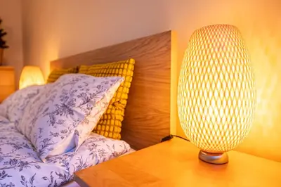 a lamp sitting on a table next to a bed at Nice and specious two bedrooms apartment in the Kraków Old Town in Kraków