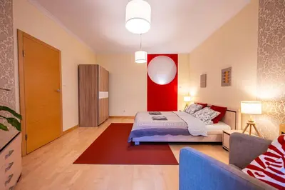 a bedroom with a bed and a red wall at Nice and specious two bedrooms apartment in the Kraków Old Town in Kraków