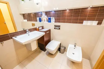 a bathroom with a white toilet and a sink at Nice and specious two bedrooms apartment in the Kraków Old Town in Kraków