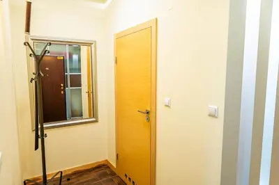 a bathroom with a wooden door and a window at Nice and specious two bedrooms apartment in the Kraków Old Town in Kraków