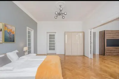 a white bedroom with a large bed and a chandelier at Malila Premium Apartments Cracow City Rtm Zbigniewa Dunin Wąsowicza 4 in Kraków