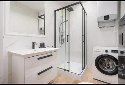 a bathroom with a sink and a washing machine at Malila Premium Apartments Cracow City Rtm Zbigniewa Dunin Wąsowicza 4 in Kraków