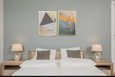 two beds in a room with paintings on the wall at Malila Premium Apartments Cracow City Rtm Zbigniewa Dunin Wąsowicza 4 in Kraków
