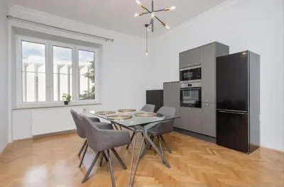 a kitchen with a table and chairs and a refrigerator at Malila Premium Apartments Cracow City Rtm Zbigniewa Dunin Wąsowicza 4 in Kraków