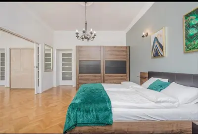 a bedroom with a large bed and a chandelier at Malila Premium Apartments Cracow City Rtm Zbigniewa Dunin Wąsowicza 4 in Kraków