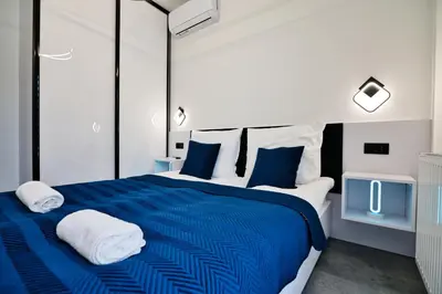 a bedroom with a blue and white bed with towels at Zatorski Apartament na Jaśminowej in Zator