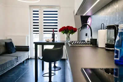 a kitchen with a counter and a table and a couch at Zatorski Apartament na Jaśminowej in Zator
