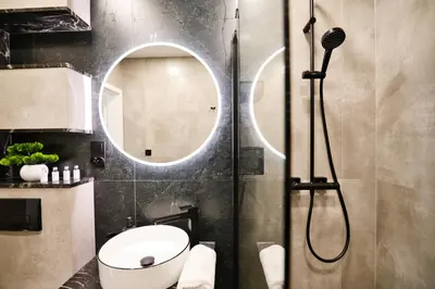 a bathroom with a shower with a toilet and a mirror at Zatorski Apartament na Jaśminowej in Zator