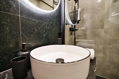 a bathroom with a sink and a mirror and a toilet at Zatorski Apartament na Jaśminowej in Zator