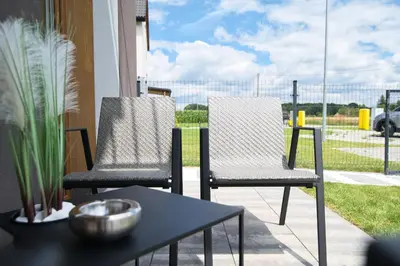 two chairs and a table on a patio at Zatorski Apartament na Jaśminowej in Zator