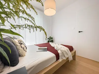 a bedroom with a bed with a plant at Klimeckiego Luxury Apartments 189 in Kraków