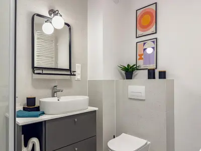 a bathroom with a sink and a mirror and a toilet at Klimeckiego Luxury Apartments 189 in Kraków