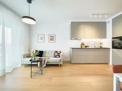 a living room with a couch and a kitchen at Klimeckiego Luxury Apartments 189 in Kraków