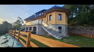 a house with a staircase in front of a fence at Villa na pagórku Limanowa in Mordarka