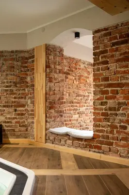 a brick wall with a bench in a room at Villa na pagórku Limanowa in Mordarka