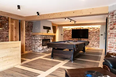 a living room with a pool table and a brick wall at Villa na pagórku Limanowa in Mordarka