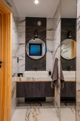 a bathroom with two sinks and a television on the wall at Villa na pagórku Limanowa in Mordarka