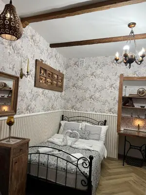 a bedroom with a bed in a room with wallpaper at Antique apartment in Krakow in Kraków