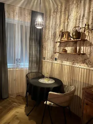 a dining room with a table and chairs and a chandelier at Antique apartment in Krakow in Kraków