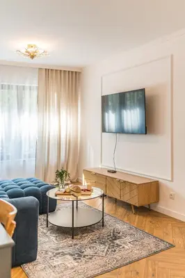 a living room with a blue couch and a tv at Kraków Libra Apartment - AC - by Rentujemy in Kraków