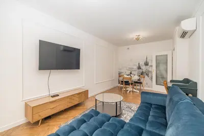 a living room with a blue couch and a tv at Kraków Libra Apartment - AC - by Rentujemy in Kraków