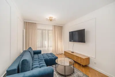 a living room with a blue couch and a tv at Kraków Libra Apartment - AC - by Rentujemy in Kraków