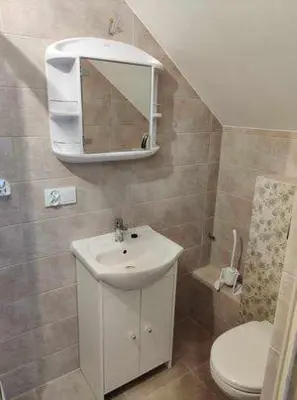 a bathroom with a sink and a toilet and a mirror at Świnna Poręba Rooms in Świnna Poręba