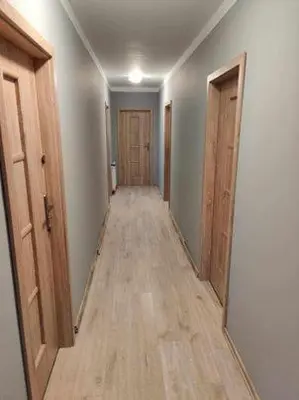 an empty hallway with wood floors and two doors at Świnna Poręba Rooms in Świnna Poręba