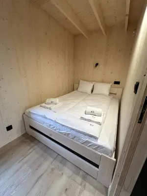 a small bed in a small room with white sheets at Mucharskie Zacisze in Zagórze