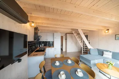 a kitchen and living room with a table and chairs at Mucharskie Zacisze in Zagórze