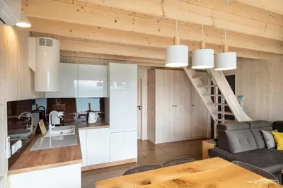 a kitchen and a living room with a staircase at Mucharskie Zacisze in Zagórze