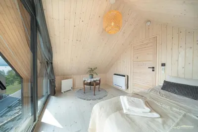 an attic bedroom with a bed and a table at Mucharskie Zacisze in Zagórze