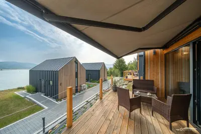 a house with a deck with a view of the water at Mucharskie Zacisze in Zagórze