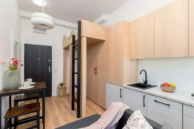 a kitchen and a living room with a table and a counter at Smart Studio 5 in Kraków