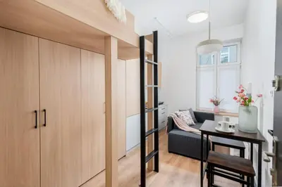 a small apartment with a loft bed and a table at Smart Studio 5 in Kraków