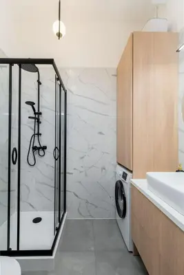 a bathroom with a shower and a washing machine at Smart Studio 5 in Kraków