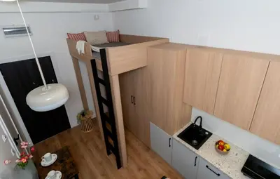 a small room with a bunk bed and a sink at Smart Studio 5 in Kraków