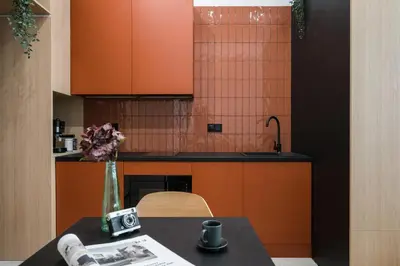 a kitchen with orange cabinets and a table with a camera at D21 Art Vintage Old Town in Kraków