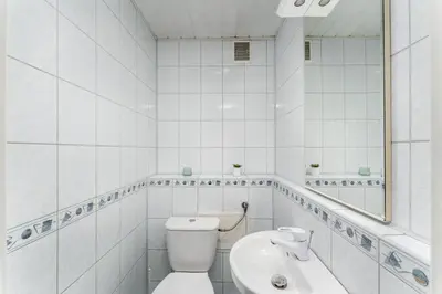 a white bathroom with a toilet and a sink at Park Zakrzówek Spacious Apartment by BookingHost in Kraków