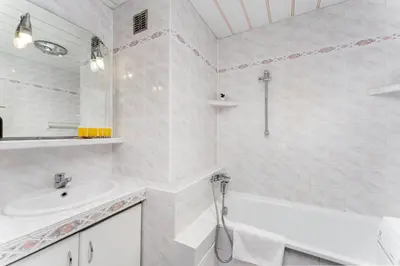a white bathroom with a tub and a sink at Park Zakrzówek Spacious Apartment by BookingHost in Kraków