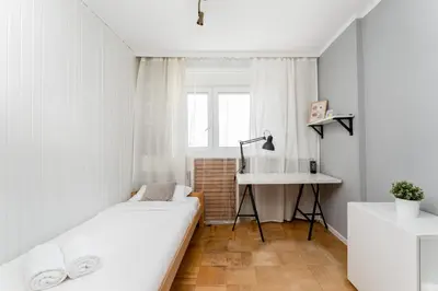 a bedroom with a bed and a desk and a sink at Park Zakrzówek Spacious Apartment by BookingHost in Kraków