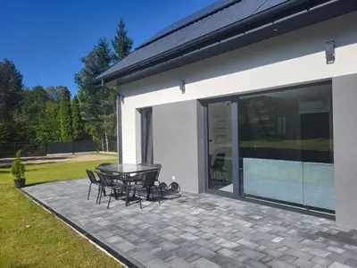 a patio with a table and chairs next to a house at Domek Całoroczny in Stróża