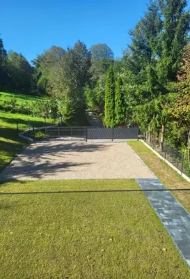 a walkway through a park with trees and grass at Domek Całoroczny in Stróża