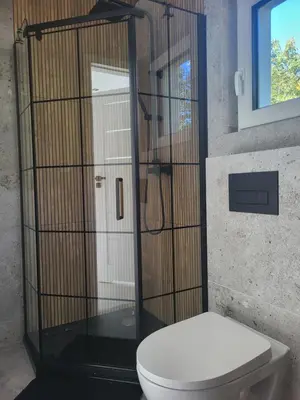 a bathroom with a toilet and a shower at Domek Całoroczny in Stróża
