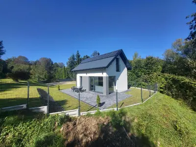 a small white house on top of a hill at Domek Całoroczny in Stróża
